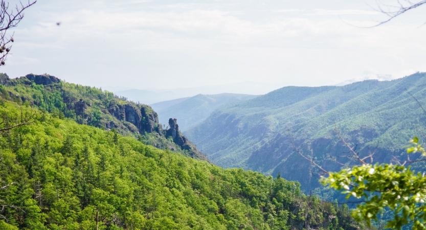 From above, a green mountain landscape stretches out below. 